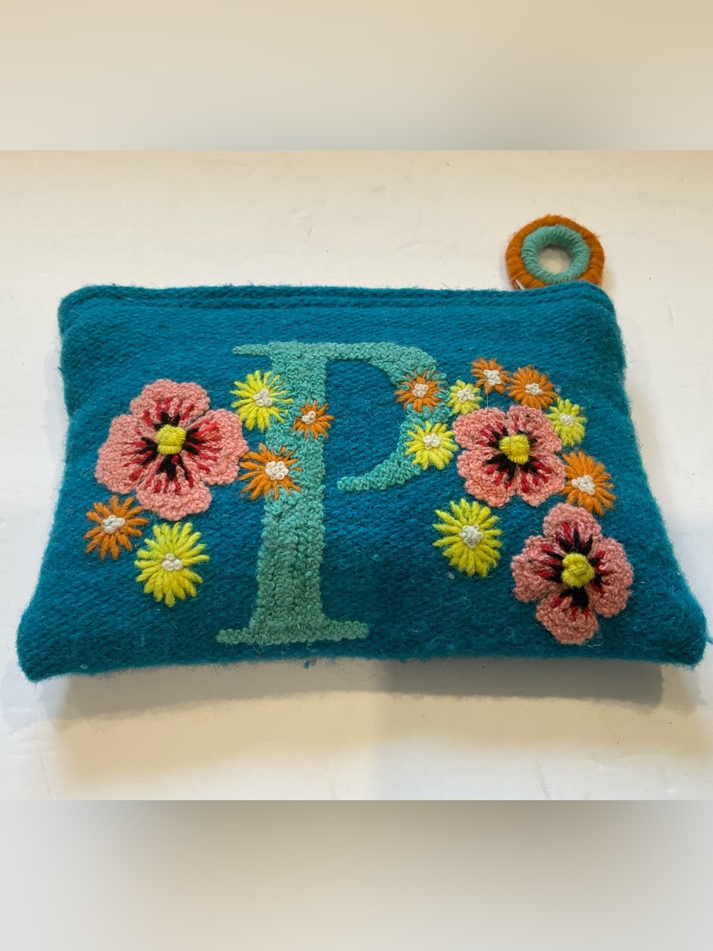This is a hand-embroidered wool initial pouch from Jenny Krauss.